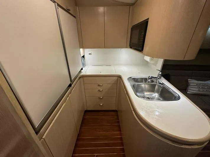 Mirabella Yacht Photos Pics 1996 Tiara Yachts 43 Open kitchen with sink, cabinets, and wood flooring.