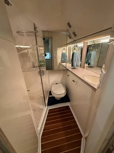 Mirabella Yacht Photos Pics Bathroom interior of 1996 Tiara Yachts 43 Open, featuring shower and wooden floor accents.