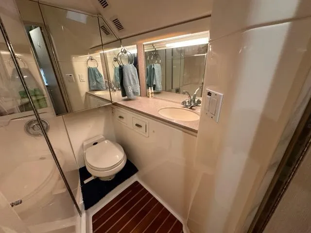 Mirabella Yacht Photos Pics Bathroom interior of 1996 Tiara Yachts 43 Open, featuring modern fixtures and wood flooring.