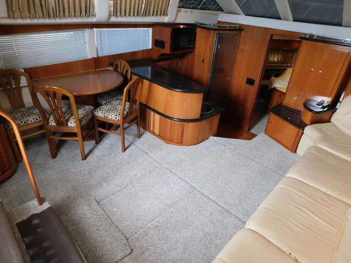 Justified Insanity II Yacht Photos Pics 2003 Carver 444 Cockpit Motor Yacht interior with dining area, kitchenette, and cozy seating.