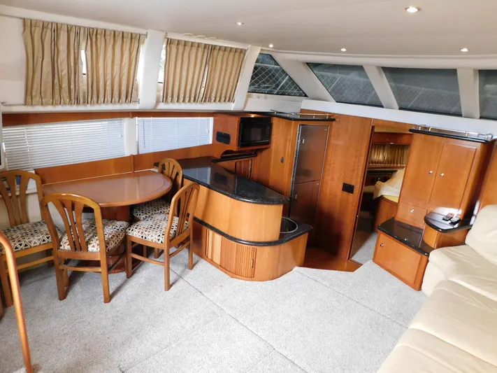 Justified Insanity II Yacht Photos Pics Luxurious interior of 2003 Carver 444 Cockpit Motor Yacht with dining area and kitchenette.