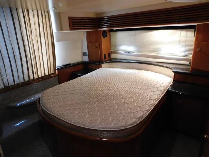Justified Insanity II Yacht Photos Pics Luxurious bedroom interior of 2003 Carver 444 Cockpit Motor Yacht with elegant wood finishes.