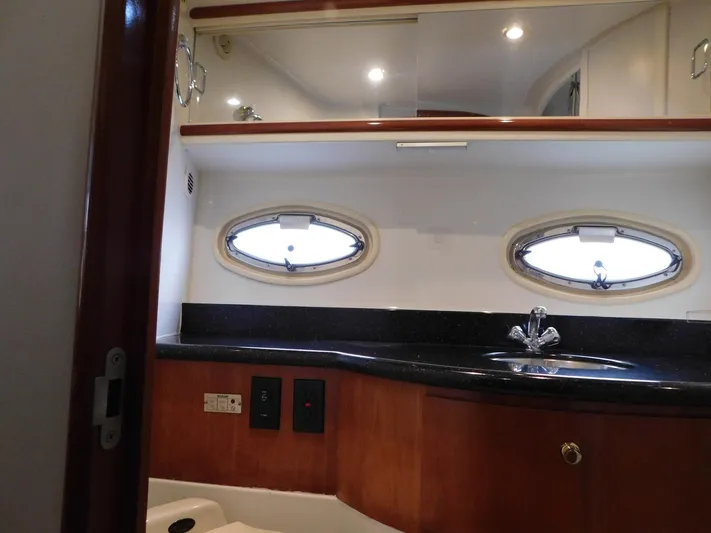 Justified Insanity II Yacht Photos Pics Interior of 2003 Carver 444 Cockpit Motor Yacht bathroom with sink and porthole windows.