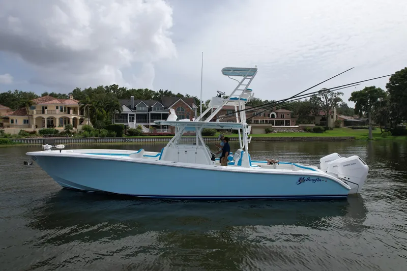  Yacht Photos Pics 2016 Yellowfin 39 Offshore boat on calm water near luxury homes.