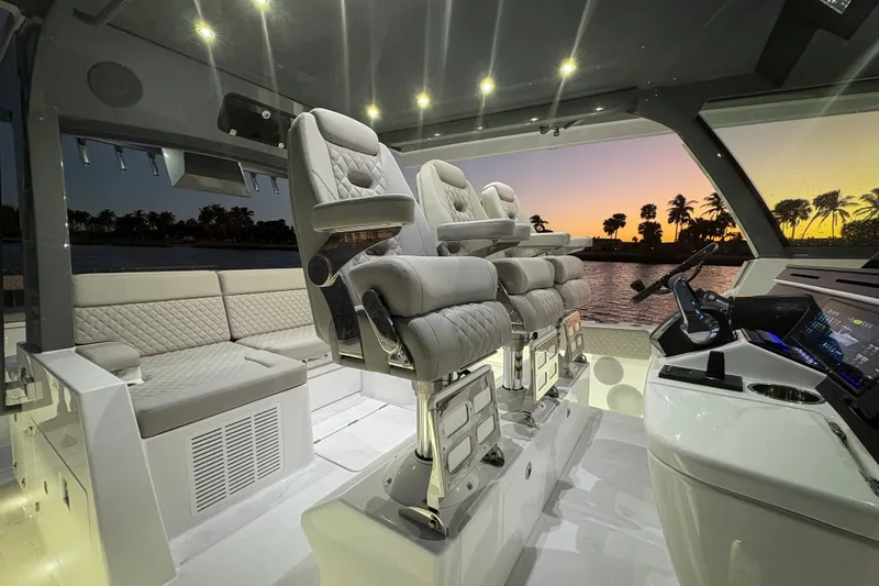  Yacht Photos Pics Luxurious interior of 2026 HCB 56 Suenos GIX yacht at sunset, featuring plush seating and modern controls.