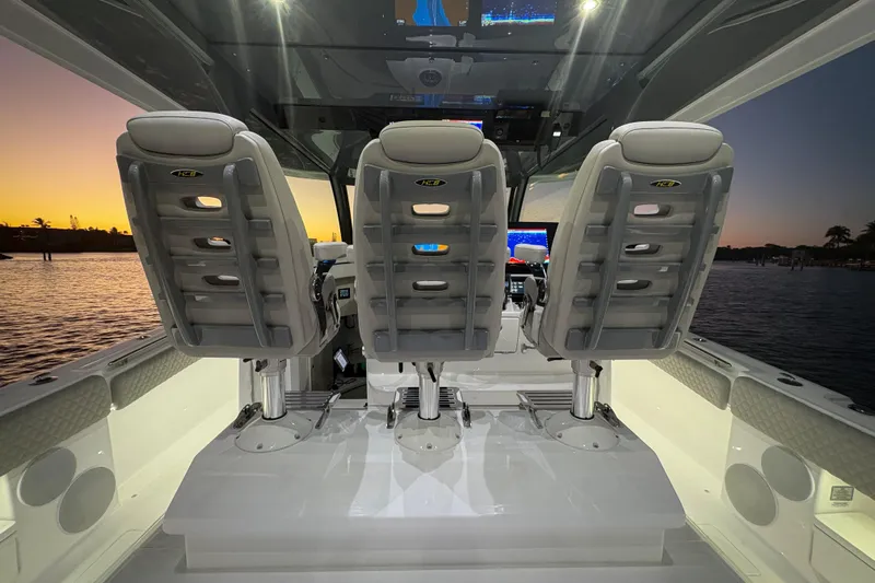  Yacht Photos Pics Interior of 2026 HCB 56 Suenos GIX boat at sunset, featuring three helm seats.