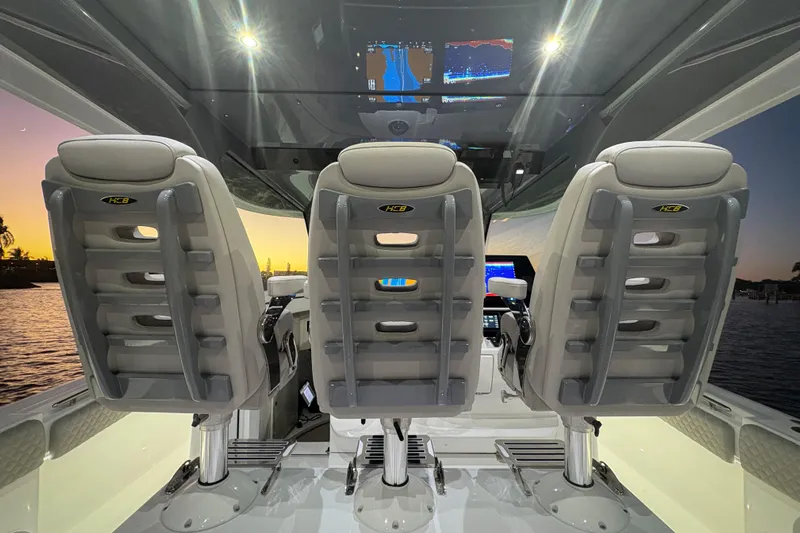  Yacht Photos Pics Interior of 2026 HCB 56 Suenos GIX boat with three luxury seats at sunset.