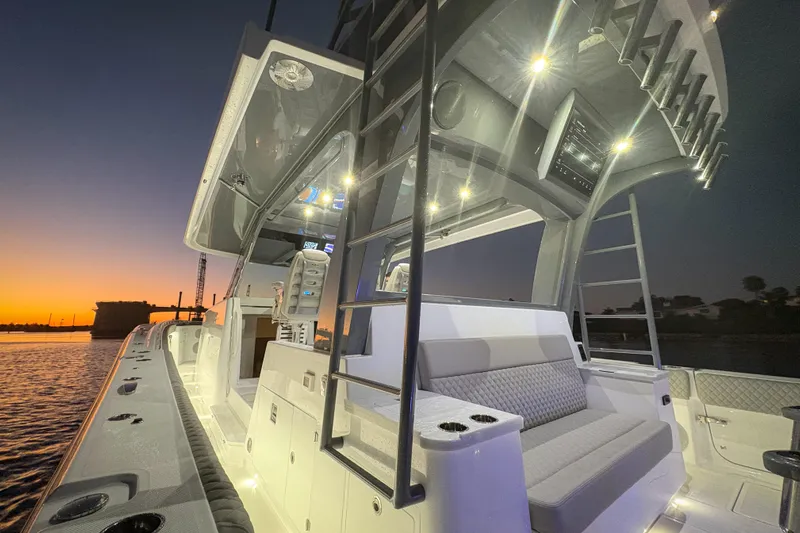  Yacht Photos Pics 2026 HCB 56 Suenos GIX yacht at sunset, featuring illuminated deck and seating area.