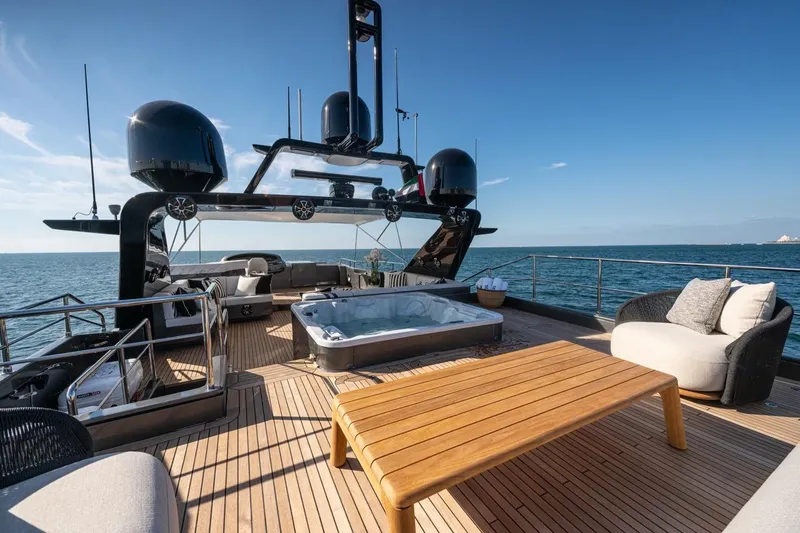 Spectre Yacht Photos Pics Luxurious 2004 Azimut 100 Jumbo yacht deck with jacuzzi and seating, overlooking the ocean.