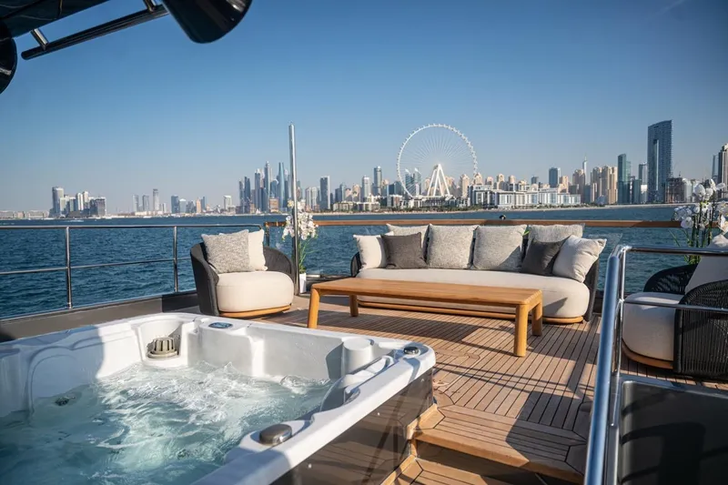 Spectre Yacht Photos Pics Luxurious Azimut 100 Jumbo yacht deck with jacuzzi, overlooking a stunning city skyline.