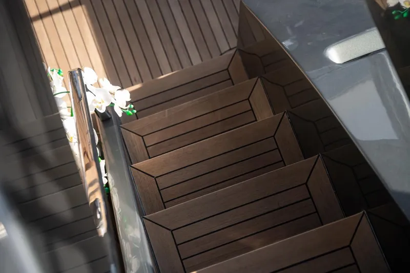 Spectre Yacht Photos Pics Wooden staircase on 2004 Azimut 100 Jumbo yacht, adorned with white flowers.