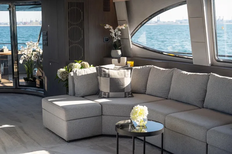 Spectre Yacht Photos Pics Luxurious interior of 2004 Azimut 100 Jumbo yacht with elegant gray sofa and ocean view.
