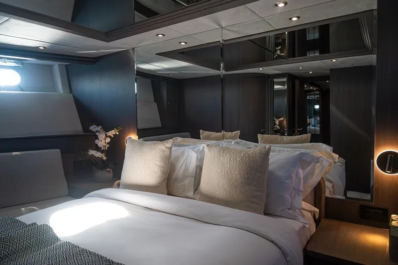 Spectre Yacht Photos Pics Luxurious bedroom interior on a 2004 Azimut 100 Jumbo yacht, featuring elegant bedding and modern lighting.