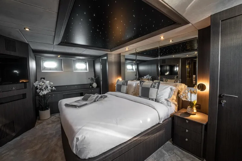 Spectre Yacht Photos Pics Luxurious bedroom interior on 2004 Azimut 100 Jumbo yacht, featuring elegant decor and ambient lighting.