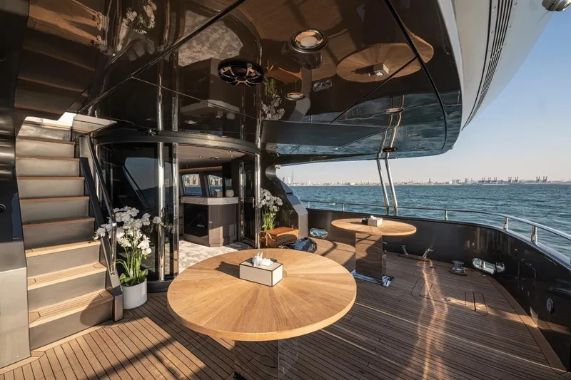 Spectre Yacht Photos Pics Luxurious 2004 Azimut 100 Jumbo yacht deck with elegant wooden tables and ocean view.