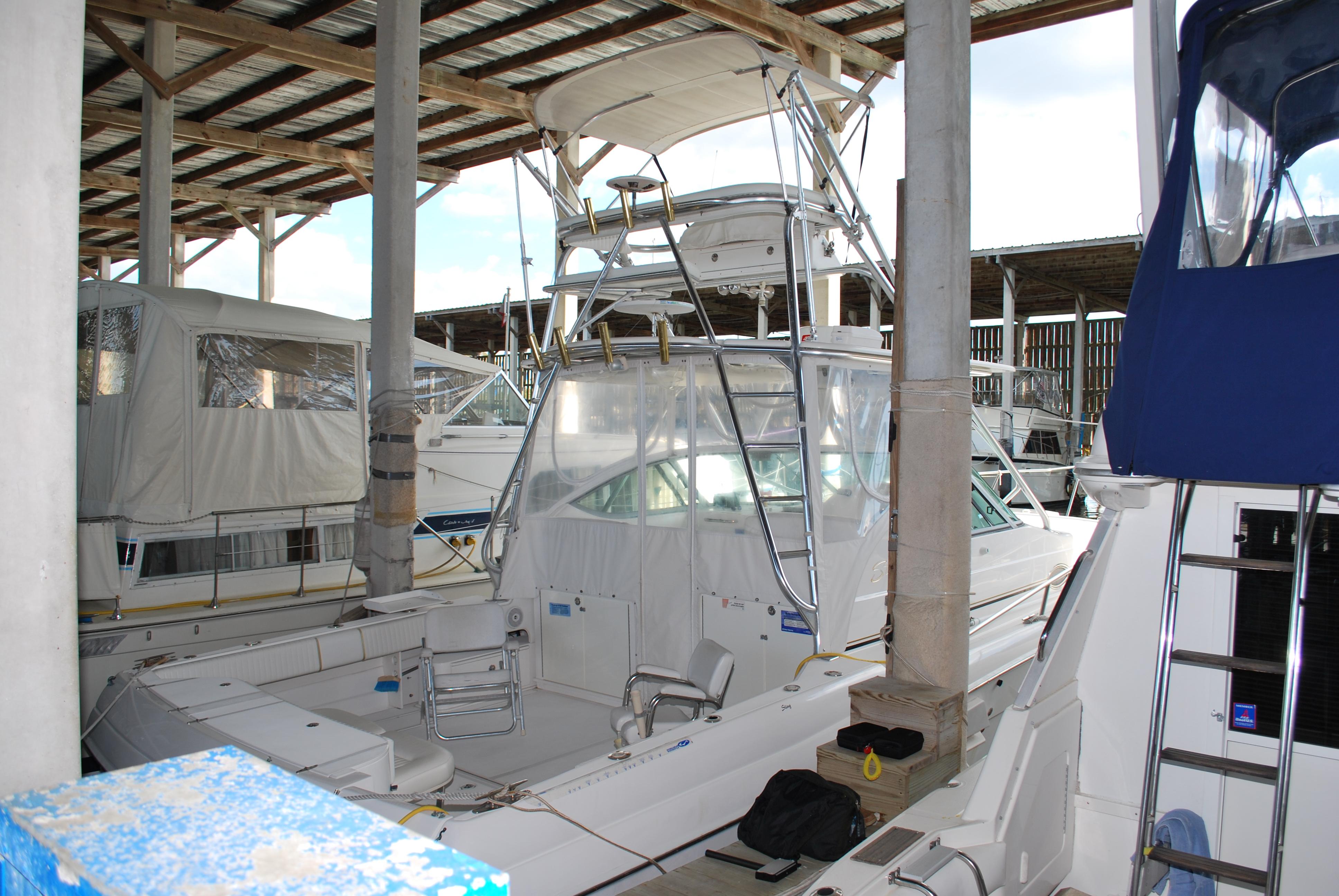 2005 Stamas 370 Express boat docked in covered marina, surrounded by other vessels.