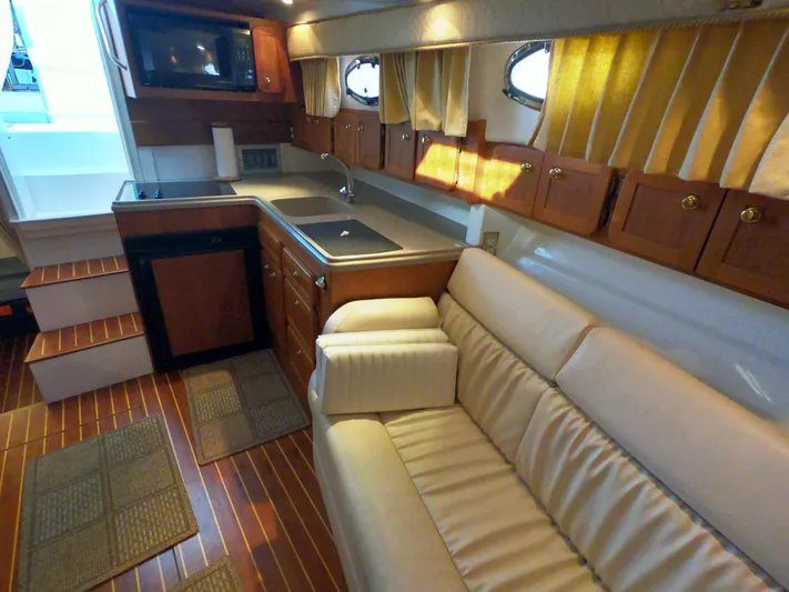  Yacht Photos Pics 2005 Stamas 370 Express interior with kitchenette, beige sofa, and wooden cabinetry.