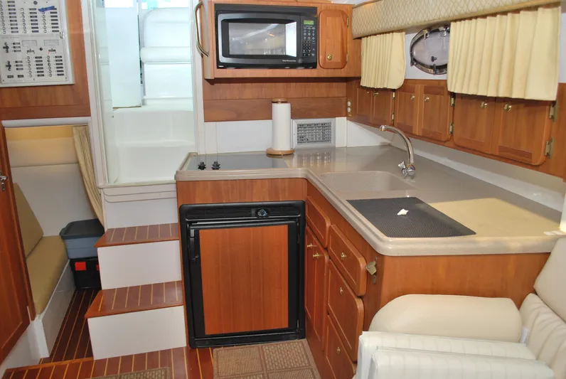  Yacht Photos Pics 2005 Stamas 370 Express yacht interior with kitchenette, microwave, and wooden cabinetry.