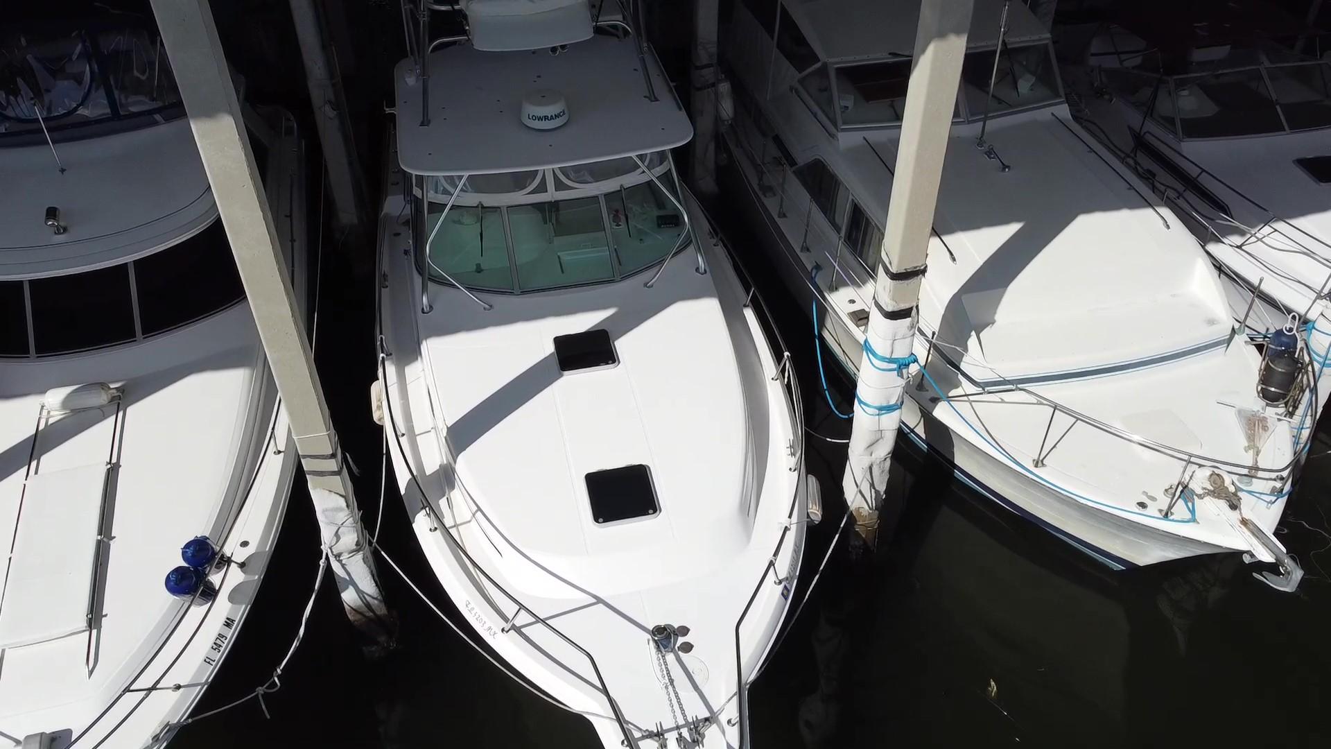 2005 Stamas 370 Express boat docked between two others, aerial view.