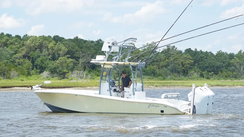  Yacht Photos Pics 2020 Yellowfin 26 Hybrid boat cruising on a river with lush green forest background.