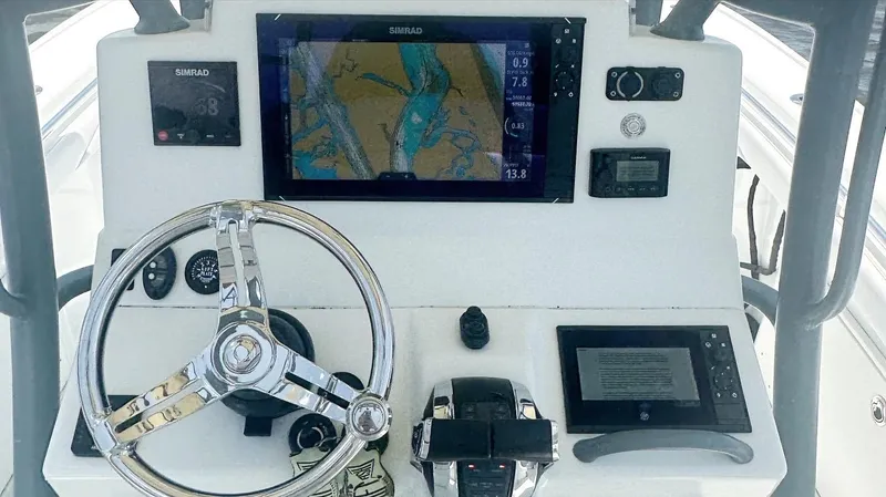  Yacht Photos Pics Control panel of a 2020 Yellowfin 26 Hybrid boat with navigation screens and steering wheel.