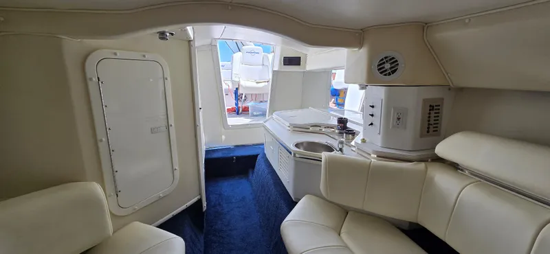  Yacht Photos Pics Interior of 2007 Fountain 42 Executioner boat with white seating and compact kitchenette.