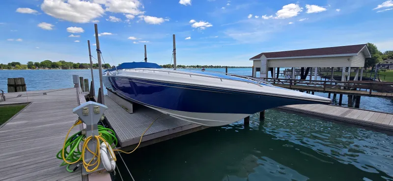  Yacht Photos Pics 2007 Fountain 42 Executioner speedboat docked by a serene lake under a clear blue sky.
