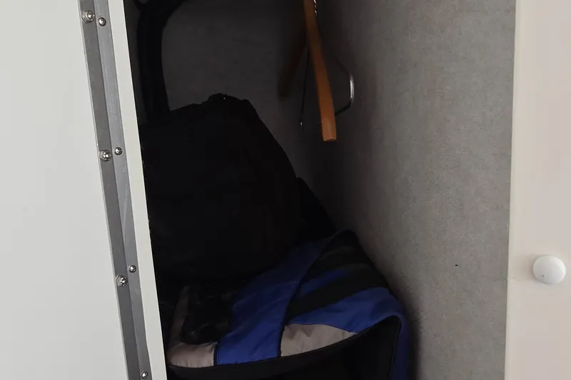  Yacht Photos Pics Storage compartment inside 2007 Fountain 42 Executioner boat, featuring bags and hangers.