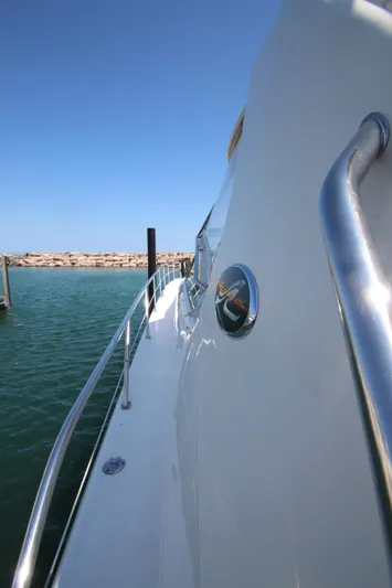  Yacht Photos Pics 2003 Sea Ray 550 Sundancer yacht side view with railing, docked in calm waters.