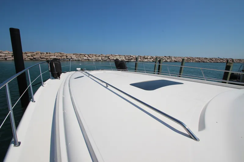  Yacht Photos Pics 2003 Sea Ray 550 Sundancer yacht deck with railing, docked by a stone breakwater.