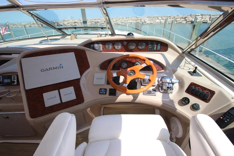  Yacht Photos Pics Helm of 2003 Sea Ray 550 Sundancer with Garmin navigation, wooden steering wheel, and gauges.