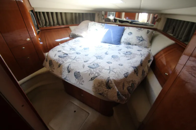  Yacht Photos Pics Luxurious cabin interior of 2003 Sea Ray 550 Sundancer with cozy bed and elegant wood finish.