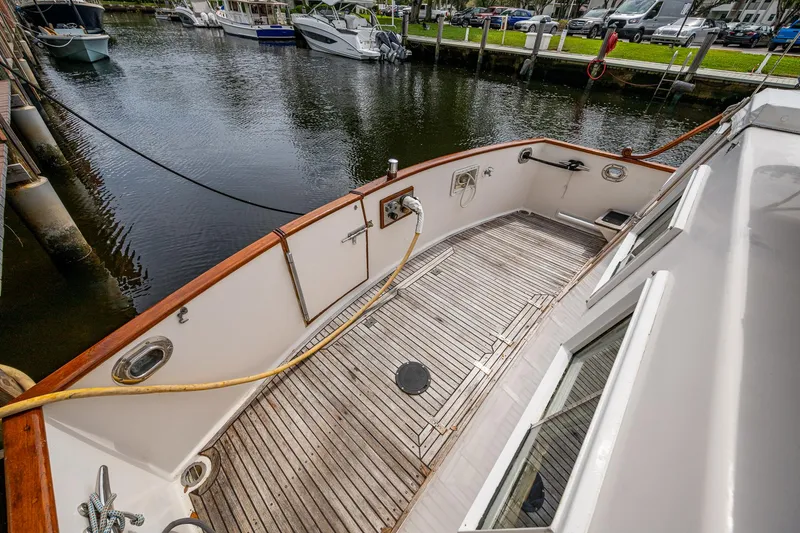 Grande Jete Yacht Photos Pics Grand Banks 46 Classic 1990 yacht deck with wooden flooring, docked by the water.