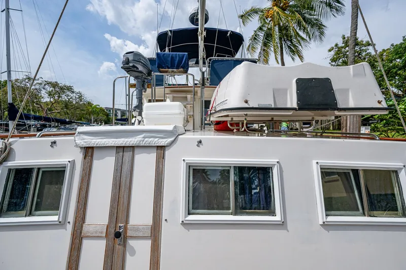 Grande Jete Yacht Photos Pics Grand Banks 46 Classic 1990 yacht with windows and equipment, docked under palm trees.