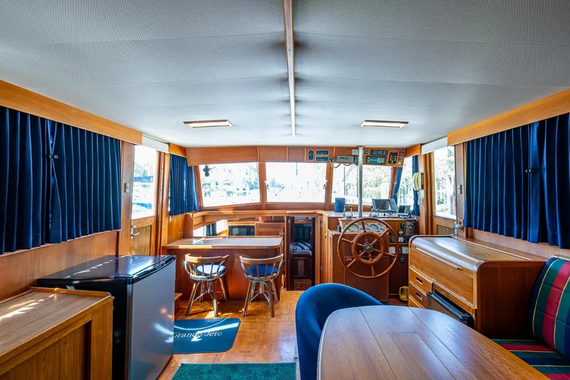 Grande Jete Yacht Photos Pics Interior of 1990 Grand Banks 46 Classic yacht with wooden furnishings and blue curtains.