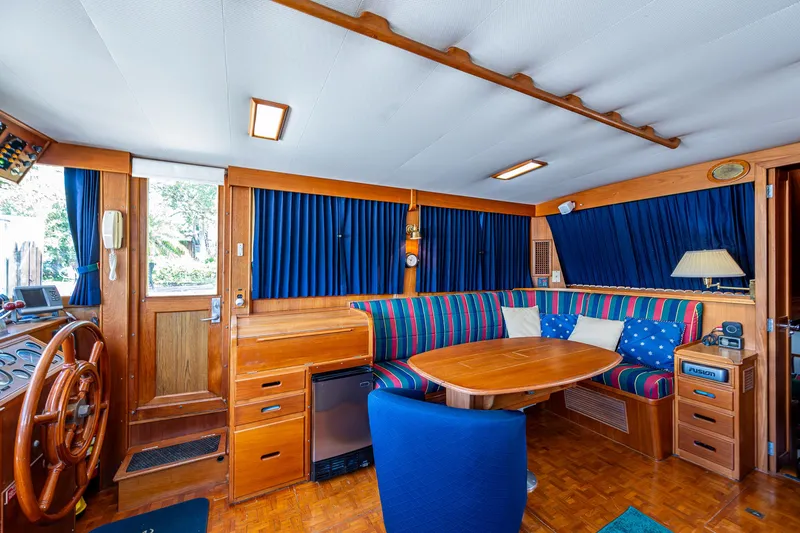 Grande Jete Yacht Photos Pics Interior of 1990 Grand Banks 46 Classic yacht with wood finish and blue-striped seating.