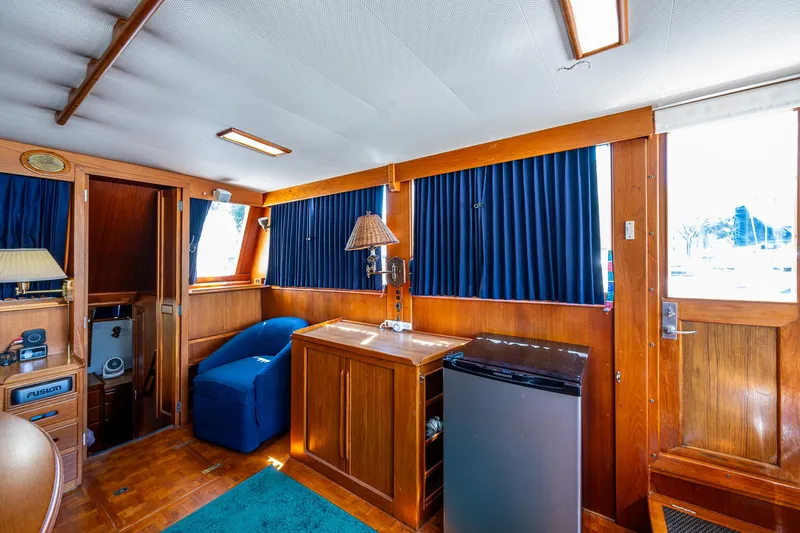 Grande Jete Yacht Photos Pics Interior of 1990 Grand Banks 46 Classic yacht with wood paneling and blue curtains.