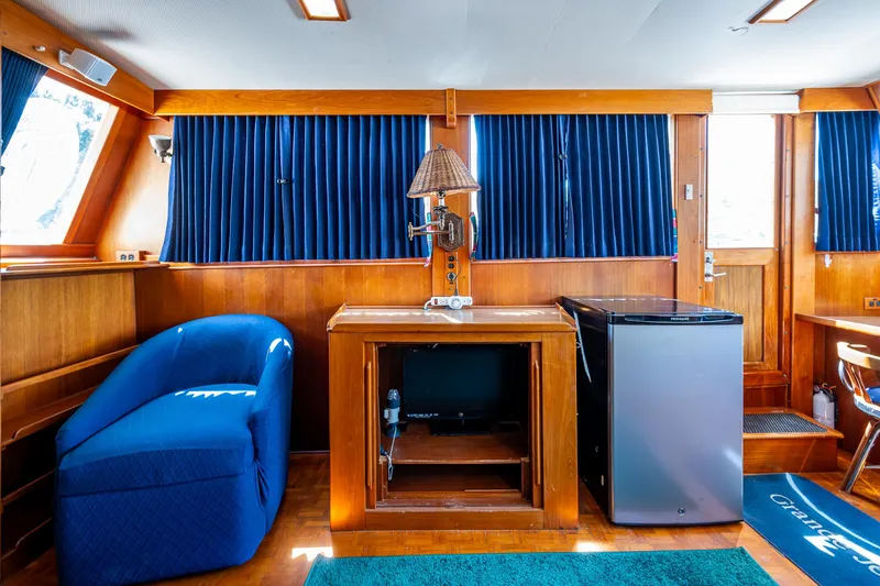 Grande Jete Yacht Photos Pics Interior of 1990 Grand Banks 46 Classic yacht with blue seating and mini fridge.