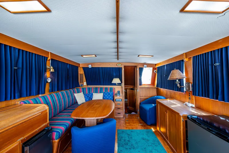 Grande Jete Yacht Photos Pics Interior of 1990 Grand Banks 46 Classic yacht with blue curtains and wooden furnishings.