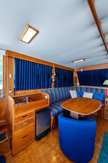 Grande Jete Yacht Photos Pics Interior of 1990 Grand Banks 46 Classic yacht with wood finish and blue upholstery.