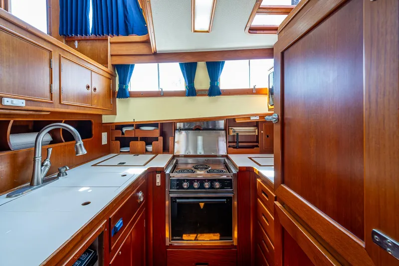 Grande Jete Yacht Photos Pics Interior of 1990 Grand Banks 46 Classic yacht kitchen with wood cabinetry and modern appliances.