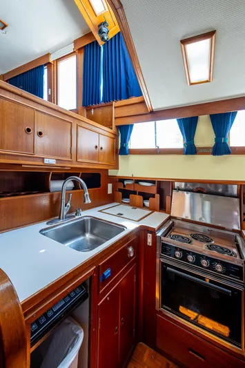 Grande Jete Yacht Photos Pics 1990 Grand Banks 46 Classic yacht kitchen with wood cabinetry, sink, and stove.
