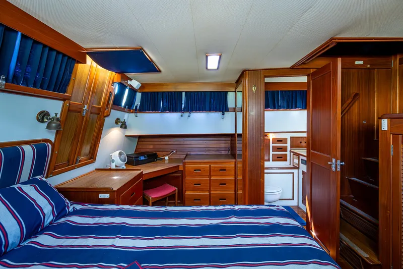 Grande Jete Yacht Photos Pics Grand Banks 46 Classic 1990 yacht interior with wood finish and striped bedding.
