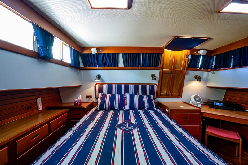 Grande Jete Yacht Photos Pics Luxurious cabin interior of a 1990 Grand Banks 46 Classic yacht with striped bedding.
