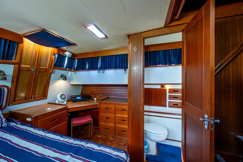 Grande Jete Yacht Photos Pics Cabin interior of 1990 Grand Banks 46 Classic yacht with wood furnishings and striped bedding.