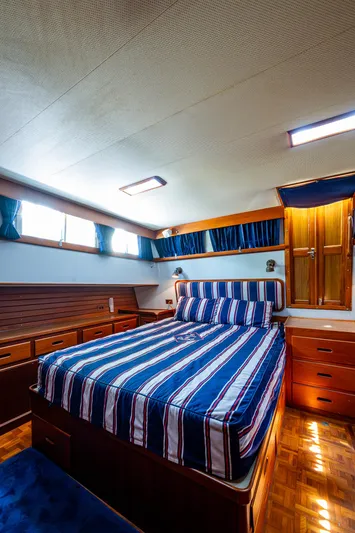 Grande Jete Yacht Photos Pics Luxurious cabin interior of 1990 Grand Banks 46 Classic yacht with striped bedding.