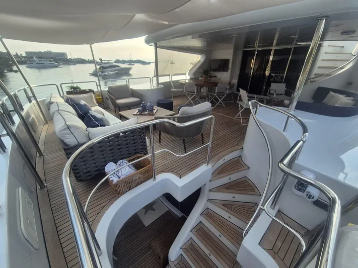 Frienship Yacht Photos Pics Luxurious Benetti Classic 115 yacht deck with elegant seating, overlooking a serene marina.