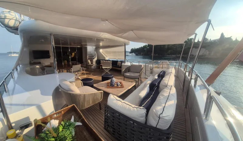 Frienship Yacht Photos Pics Luxurious deck of 2000 Benetti Classic 115 yacht with elegant seating and scenic views.