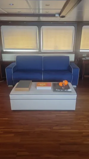 Frienship Yacht Photos Pics Luxurious yacht interior with blue sofa, modern table, and wooden flooring on a 2000 Benetti Classic 115.