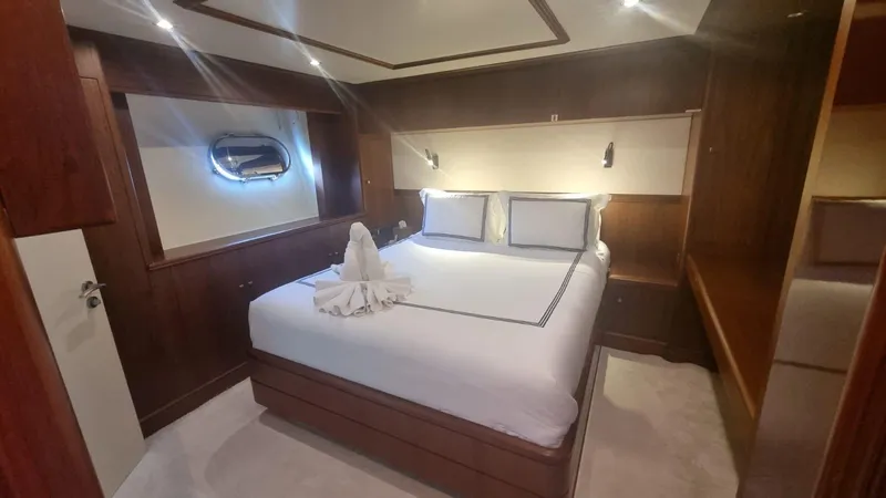 Frienship Yacht Photos Pics Luxurious bedroom interior on a 2000 Benetti Classic 115 yacht, featuring elegant wood paneling.